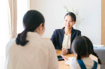 女性相談員が母親と子どもに向き合って話をしている様子